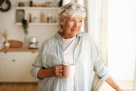 Woman having cup of coffee while looking out window